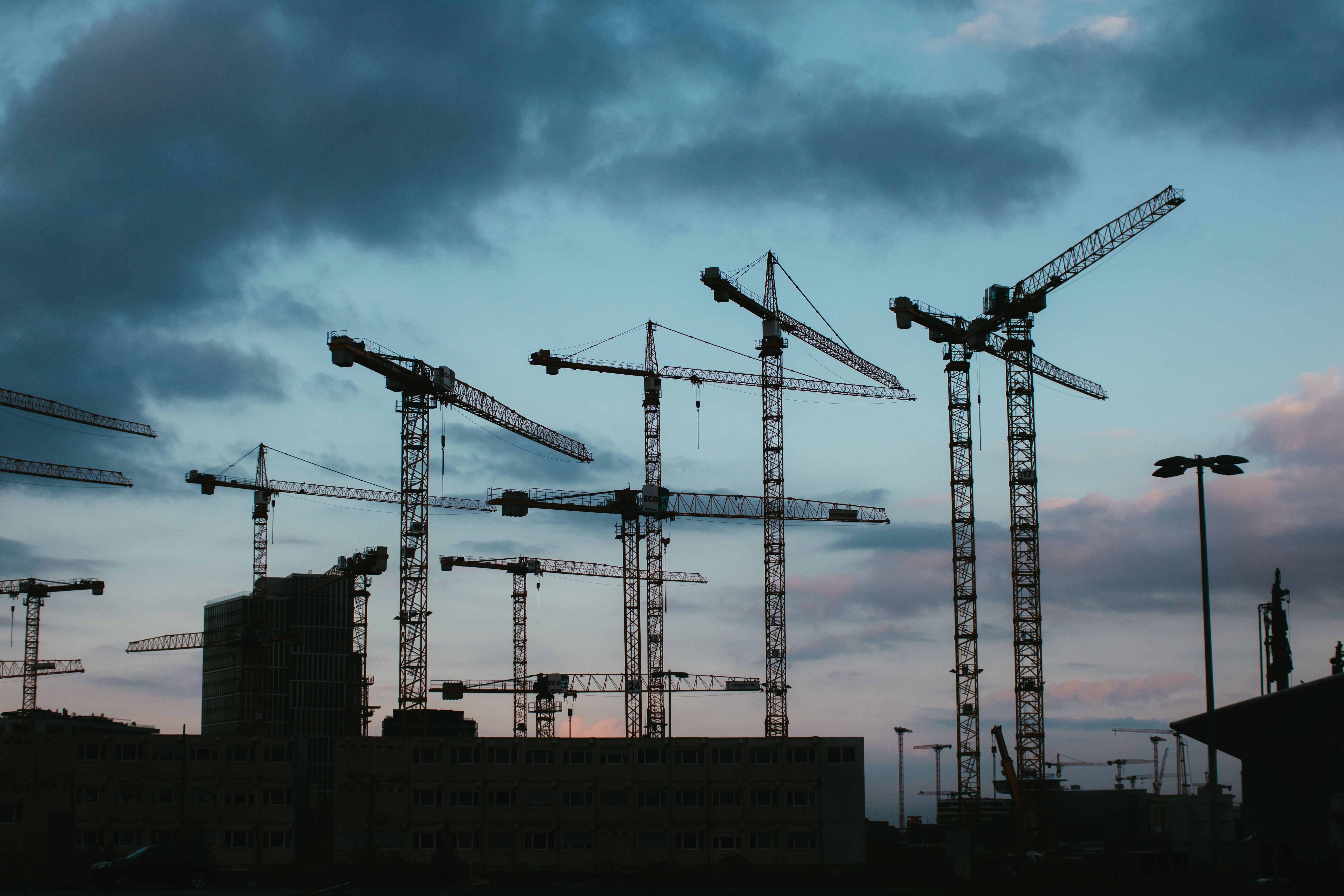 Tower cranes across a city construction skyline
